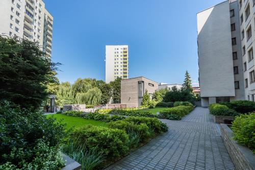 un jardín en el centro de una ciudad con edificios en Metro Wilanowska Homely Apartment, en Varsovia