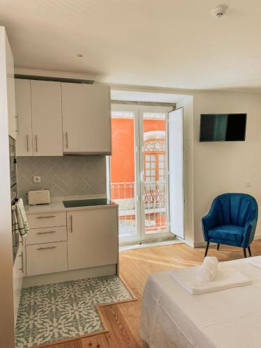 a kitchen with a bed and a blue chair in a room at Concha Setúbal Miradouro in Setúbal