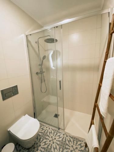 a bathroom with a shower and a toilet at Concha Setúbal Miradouro in Setúbal