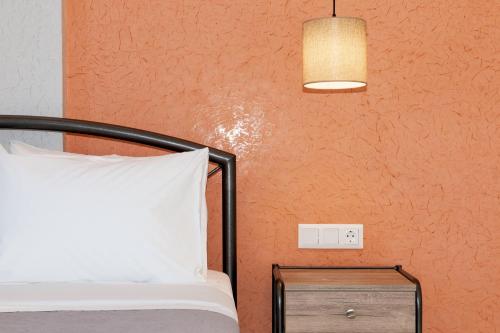 a bedroom with a bed and a lamp and a nightstand at Mylos Mountain Villas- Villa Giorgio in Agios Nikitas
