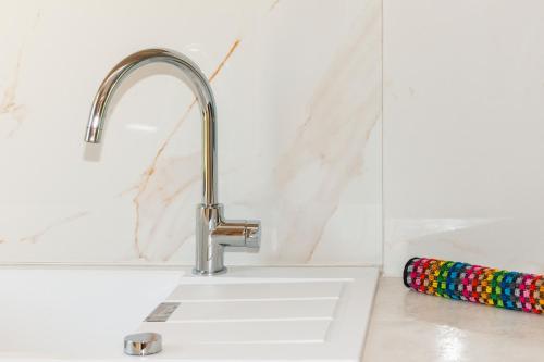 a white kitchen sink with a chrome faucet at Mylos Mountain Villas- Villa Giorgio in Agios Nikitas