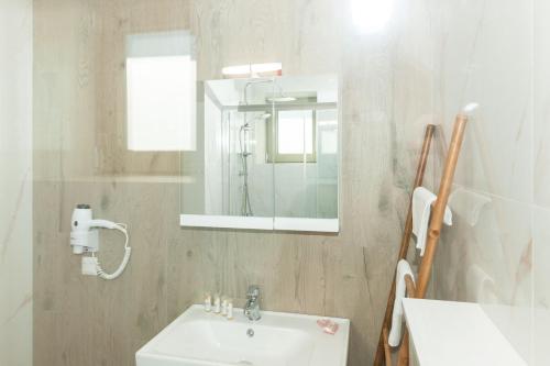 a white bathroom with a sink and a mirror at Mylos Mountain Villas- Villa Giorgio in Agios Nikitas