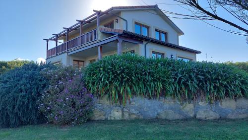 een huis bovenop een stenen muur bij VILLA&MAR LANGRE BEACH in Langre