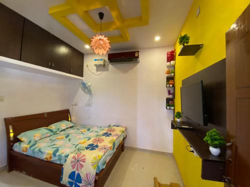 a bedroom with a bed and a flat screen tv at Rock N riveR in Malpe