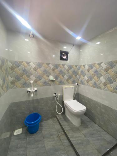 a bathroom with a toilet and a blue bucket at Rock N riveR in Malpe