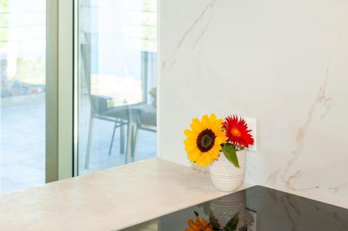 a vase filled with flowers sitting on a counter at Mylos Mountain Villas- Villa Giorgio in Agios Nikitas