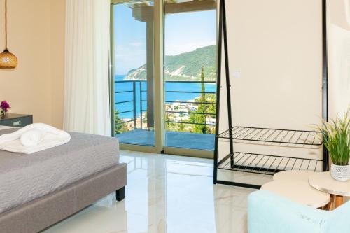 a bedroom with a bed and a view of the ocean at Mylos Mountain Villas- Villa Giorgio in Agios Nikitas