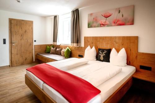 a bedroom with a large bed with a red blanket on it at Zistelberghof in Werfenweng