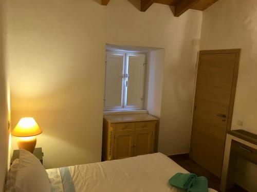sypialnia z łóżkiem, oknem i lampką w obiekcie Casa do Pátio em Alcantarilha - Algarve w mieście Alcantarilha