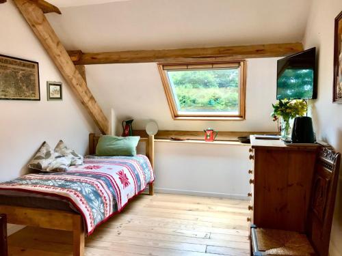a bedroom with a bed and a window at La Ville de Mainguy in Josselin