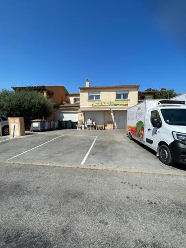 a white van parked in a parking lot in front of a building at Appartement spacieux et moderne avec un extérieur in Ramatuelle