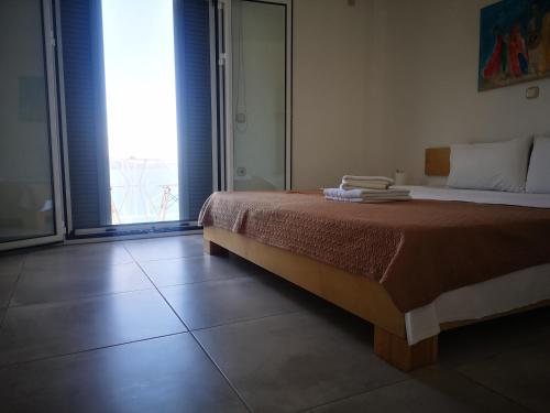 a bedroom with a bed and a large window at 12 Gods Resort in Pylos