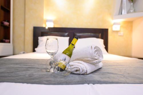 a bottle of champagne and a glass on a bed at Rom Mansion in Rosh Pinna