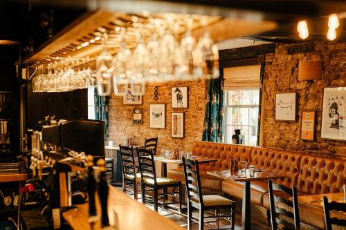 a restaurant with tables and chairs in a room at The Castle Inn in Castle Combe
