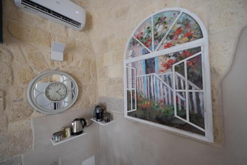 a bathroom with a window and a clock on a wall at B&B Talino in Trani