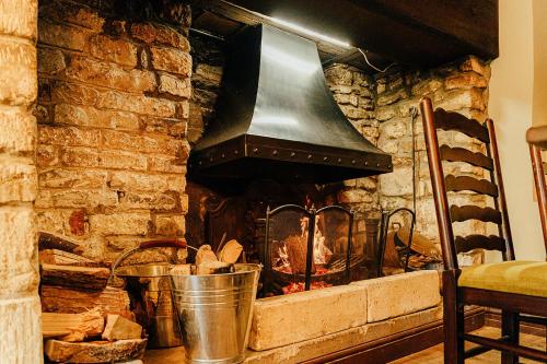 a stone fireplace with a large bell in it at The Castle Inn in Castle Combe