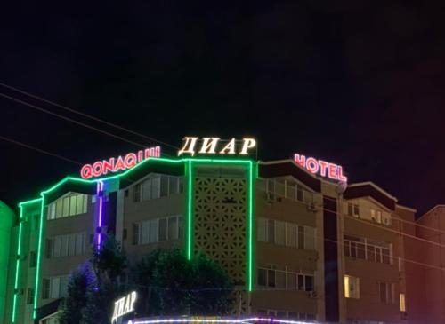 a hotel with neon signs on top of it at Diar in Atyraū