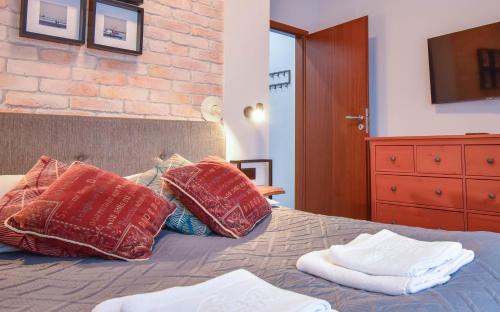 a bedroom with a bed with three pillows on it at Apartamenty Na Wyspie - Baltic Park - Apartamenty z sypialnią i parkingiem - ul Uzdrowiskowa 24-34 in Świnoujście