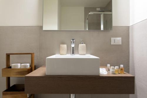 La salle de bains est pourvue d'un lavabo blanc sur un comptoir en bois. dans l'établissement Residenza SubitoSanto - Appartamento con balconcino "3B", à Padoue