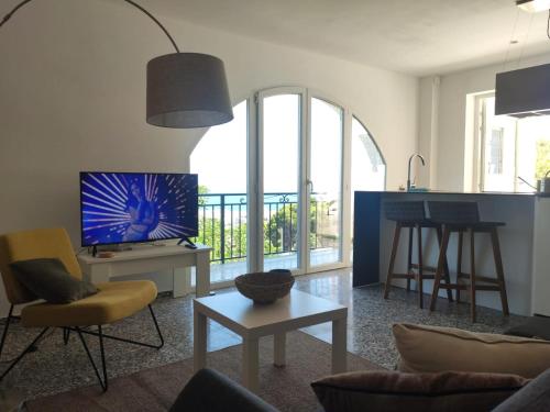 a living room with a couch and a tv and a table at Casa Muk in Calpe