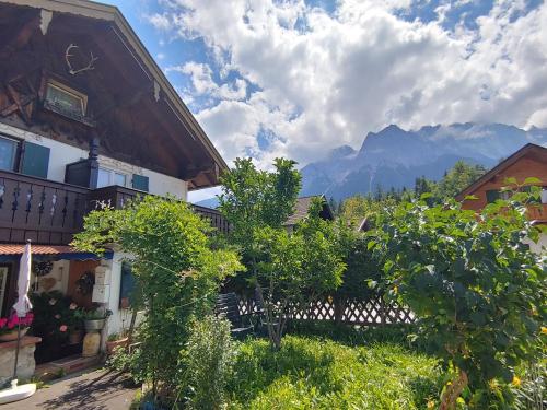 uma vista para uma casa com montanhas ao fundo em Loisachtalerhof em Grainau