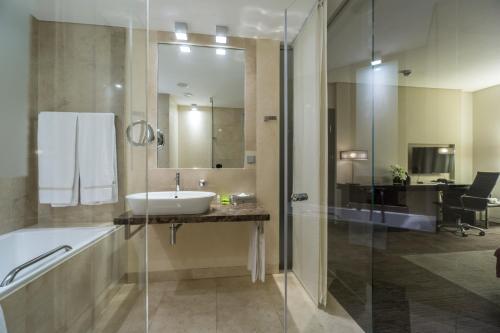 a bathroom with a sink and a tub and a shower at Andersia Hotel & Spa Poznan, a member of Radisson Individuals in Poznań