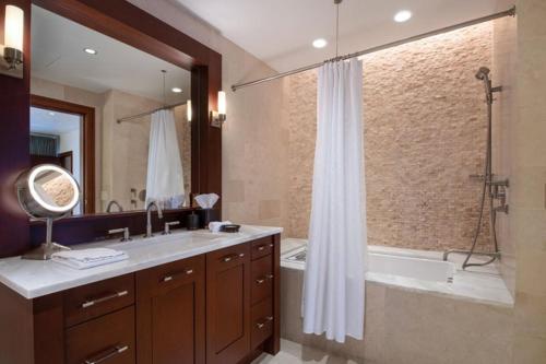 a bathroom with a tub and a sink and a shower at Platinum Vail Solaris 1 Bedroom Vacation Rental Set At The Base Of The Mountain Just Steps From The Gondola in Vail