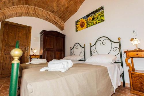 a bedroom with two beds with white sheets at BB Casale La Selva Mosciano in Mosciano SantʼAngelo