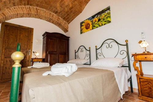 1 dormitorio con 2 camas con sábanas blancas en BB Casale La Selva Mosciano, en Mosciano SantʼAngelo