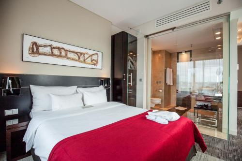 a bedroom with a large bed with a red blanket at Andersia Hotel & Spa Poznan, a member of Radisson Individuals in Poznań
