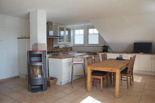 a kitchen with a wooden table and a stove at Ferienwohnung Störtebeker in Sandesneben