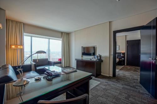 a hotel room with a desk and a living room at Andersia Hotel & Spa Poznan, a member of Radisson Individuals in Poznań