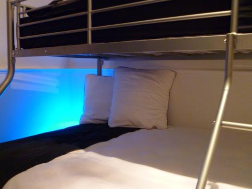 - un lit superposé avec 2 oreillers blancs dans l'établissement Aux Portes d'Honneur, à Cluny