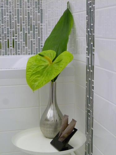 un vase avec une feuille verte sur une table dans l'établissement Aux Portes d'Honneur, à Cluny