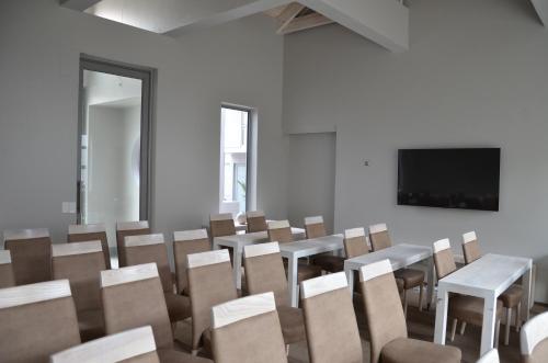 a room with chairs and tables and a flat screen tv at Be-Still Accommodation in Swakopmund