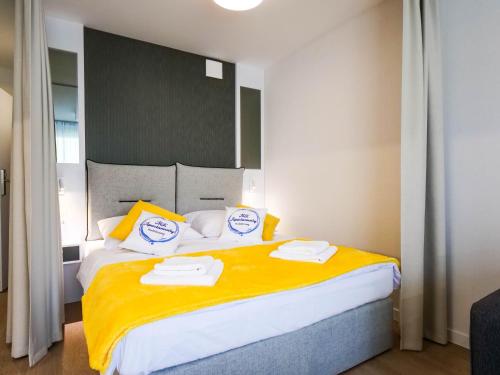 a bedroom with a large bed with two towels on it at MK Apartamenty Młyńska 10 in Kołobrzeg