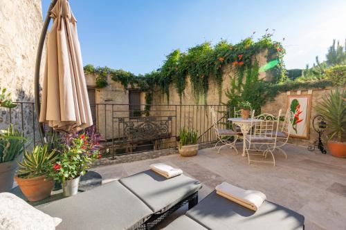a patio with an umbrella and a table and chairs at Champagne House - Elegance, Luxury and Charm in Condom