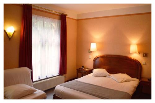 
A bed or beds in a room at Hotel La Porte de France

