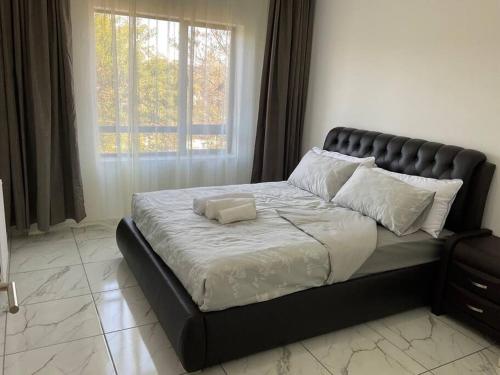 a large bed in a bedroom with a large window at Lovely 1 Bedroom Unit in an Amazing Golf Estate in Roodepoort