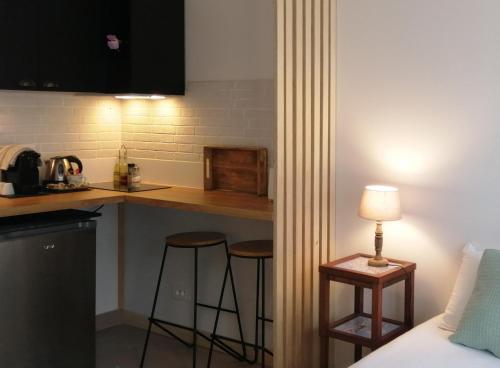 a kitchen with two bar stools in a room at VILLA VOLTAIRE in Clamart