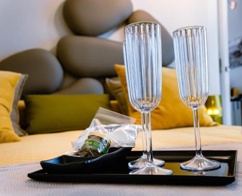 due bicchieri da vino su un vassoio nero su un tavolo di Dimora Cavour ad Amantea