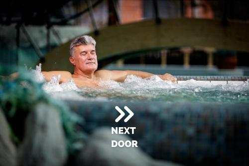 a man swimming in a swimming pool at Boutique Hotel Sunrose 7 - Gourmet & SPA in Bohinj