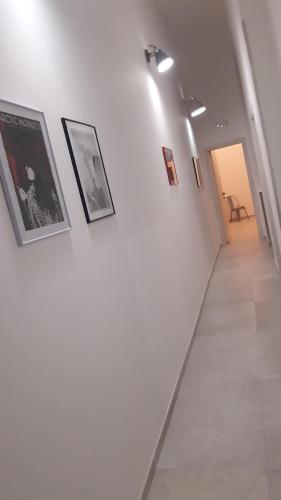 a hallway with pictures on a white wall at ANDIRIVIENI☆LECCE ☆CASA VACANZE LECCE in Lecce