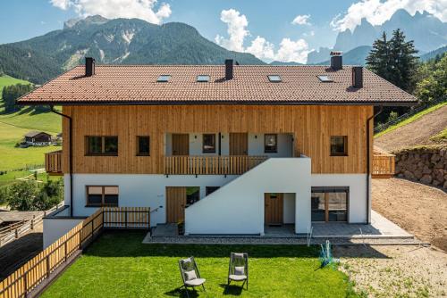 a house on a hill with two chairs at Lippmöshof Apartment Odla in Villnoss