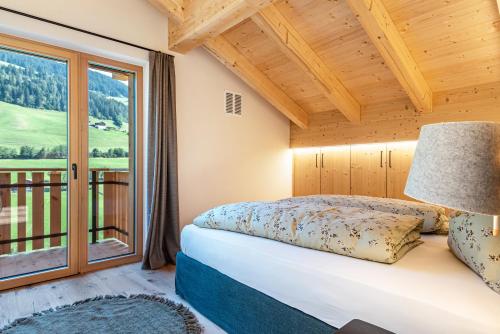 1 dormitorio con cama y ventana grande en Apartment Furca, en Villnoss