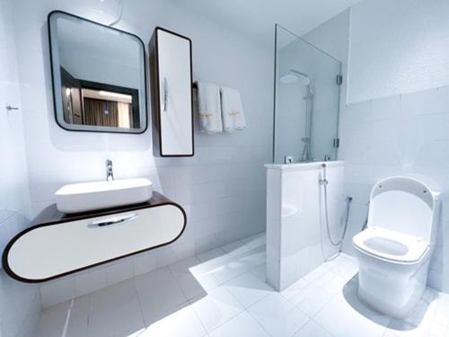 a white bathroom with a sink and a toilet at Olivia Chalet فلة أوليفيا in Al ‘Aqar