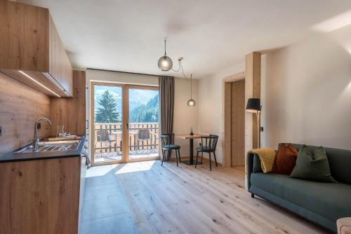 a kitchen and living room with a couch and a table at Lippmöshof Apartment Mesdi in Villnoss