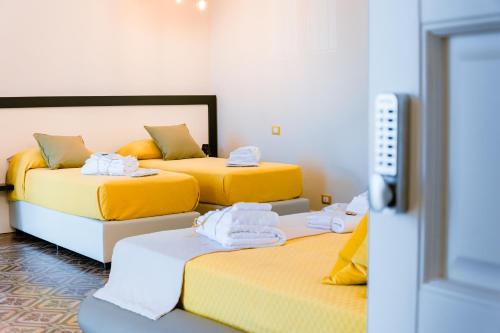 a room with two beds and a flat screen tv at Dimora Cavour in Amantea