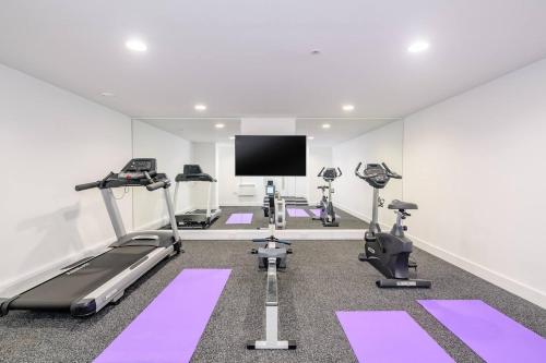 a gym with tread machines and a flat screen tv at 4br-8guests-balcony-beachview-pool-pets in Woolacombe