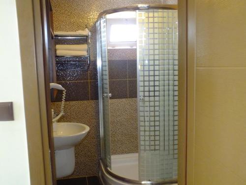 a bathroom with a shower with a sink and a toilet at Kutlugun Sahil Otel in Akcay